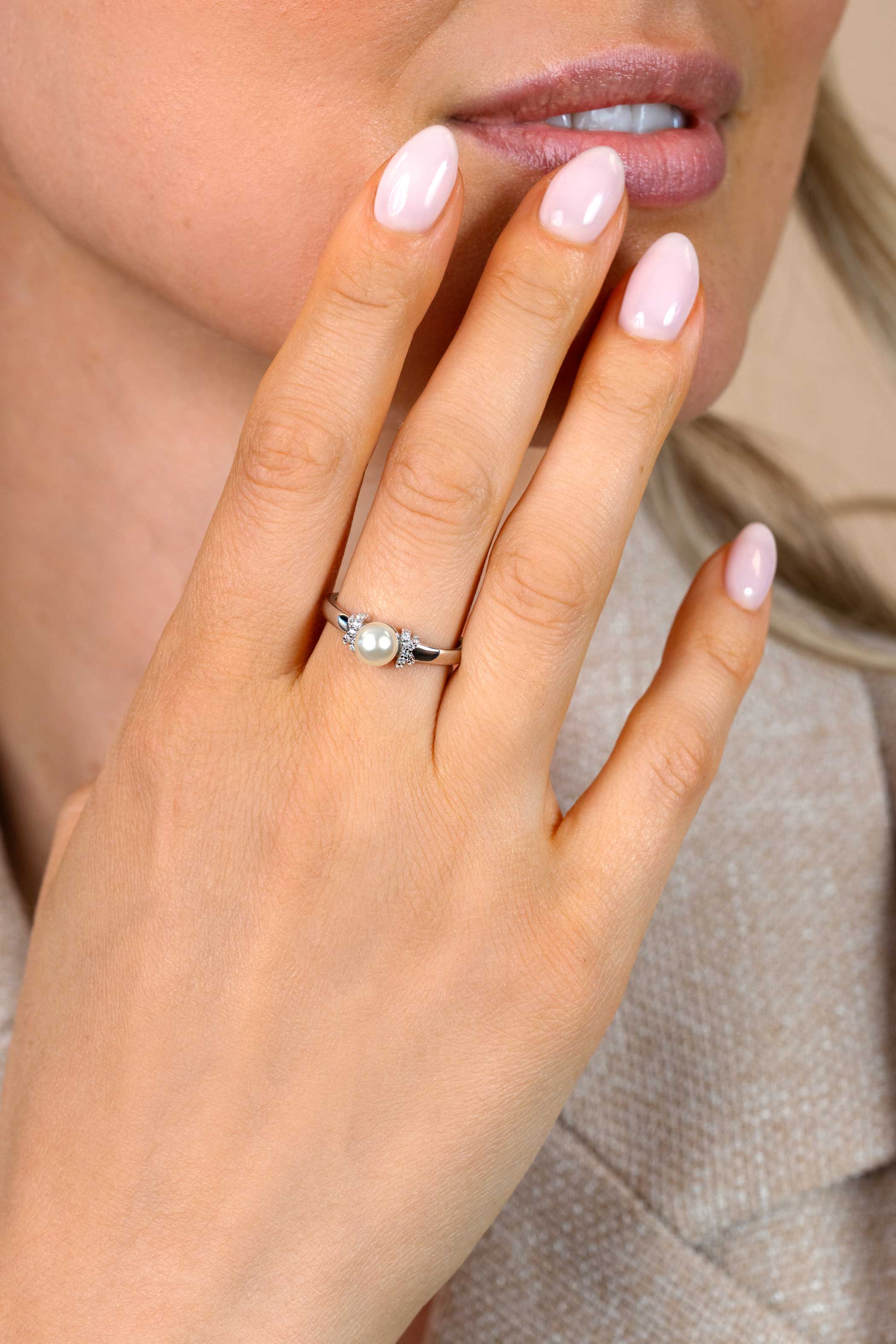 ZINZI zilveren ring met een witte parel (6mm), aan weerszijden subtiel bezet met witte zirkonia's in een strikvormige zetting ZIR2863