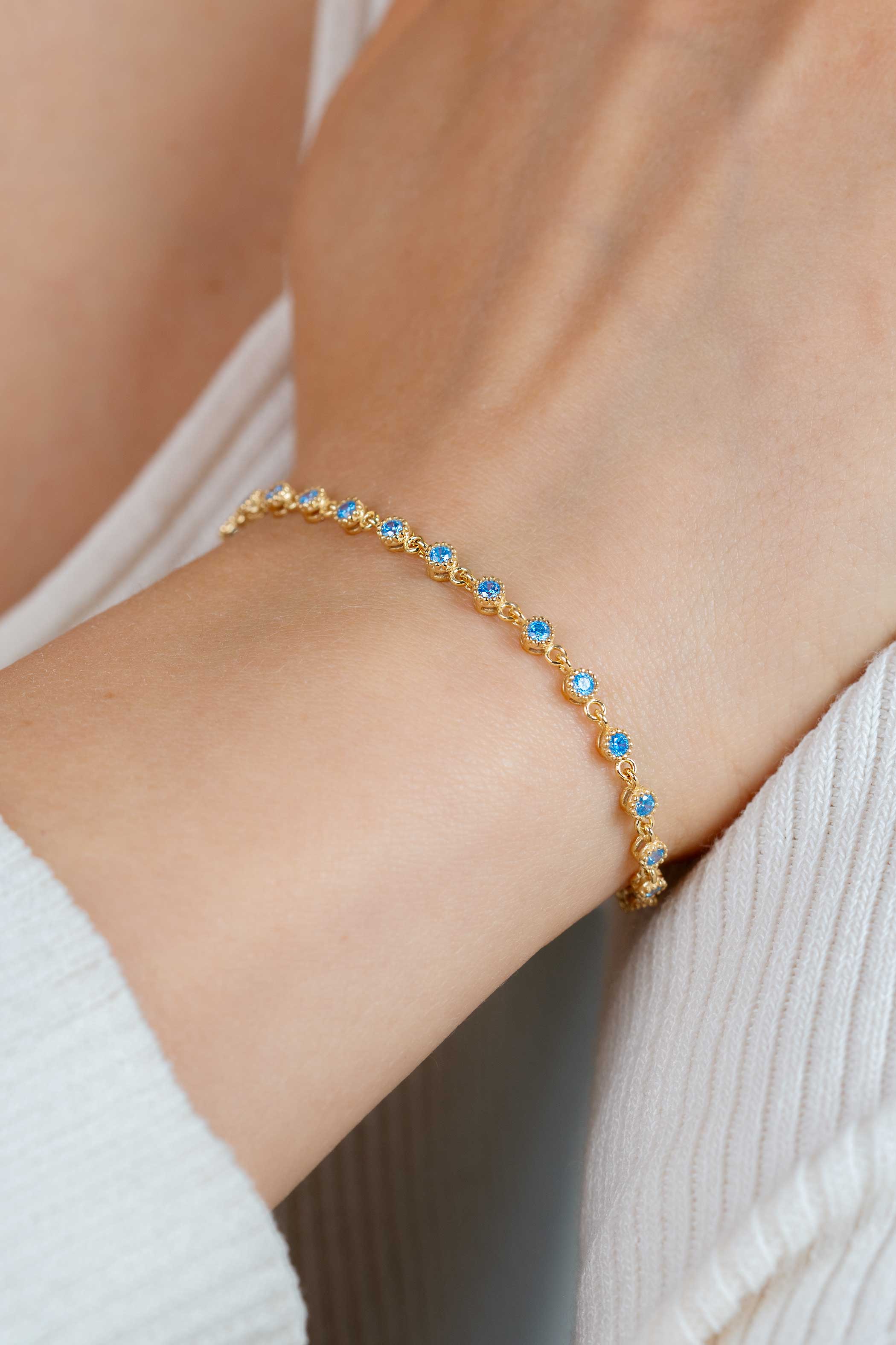 ZINZI gold plated zilveren armband met een speelse rij blauwe zirkonia’s in ronde zetting 3mm breed ZIA2893BG