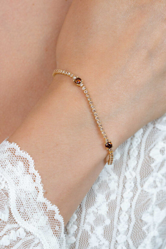 ZINZI gold plated zilveren tennisarmband 2,1mm breed bezet met champagnekleurige zirkonia’s in verfijnde rijzetting, afgewisseld met drie grotere donkerbruine kleurstenen (4,3mm) in chatonzetting ZIA2894C