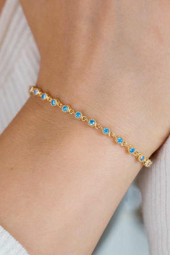 ZINZI gold plated zilveren armband met een speelse rij blauwe zirkonia’s in ronde zetting 3mm breed ZIA2893BG