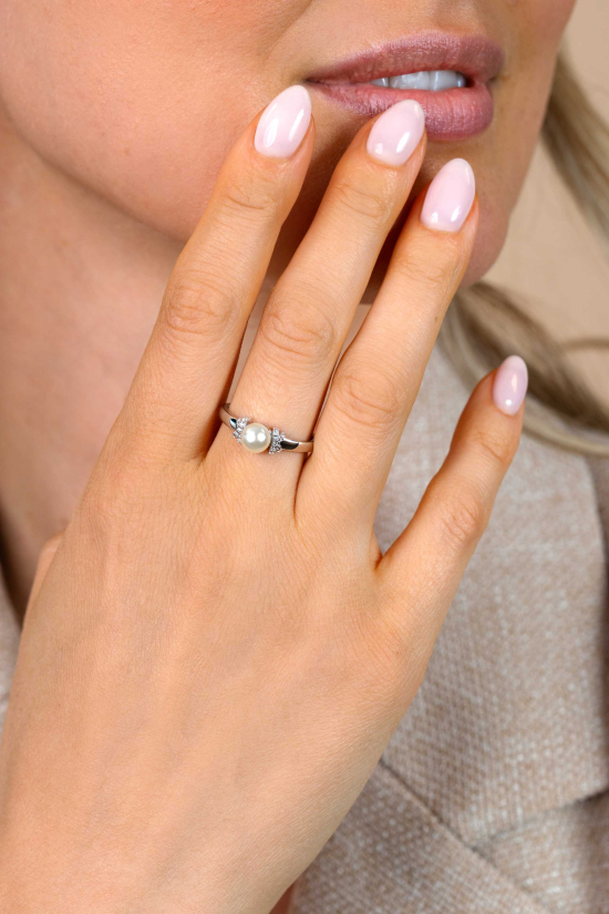 ZINZI zilveren ring met een witte parel (6mm), aan weerszijden subtiel bezet met witte zirkonia's in een strikvormige zetting ZIR2863