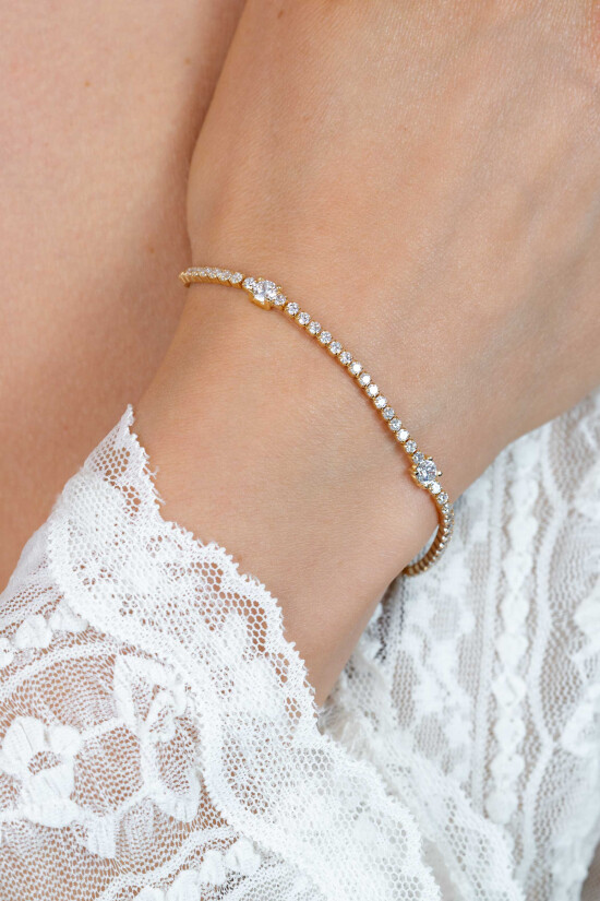ZINZI gold plated zilveren tennisarmband 2,1mm breed bezet met witte zirkonia’s in verfijnde rijzetting, afgewisseld met drie grotere witte zirkonia's (4,3mm) in chatonzetting ZIA2894Y